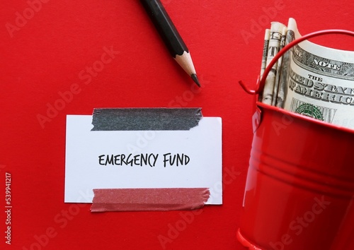 Obraz na plátně On red background, cash money with handwritten note EMERGENCY FUND, financial go