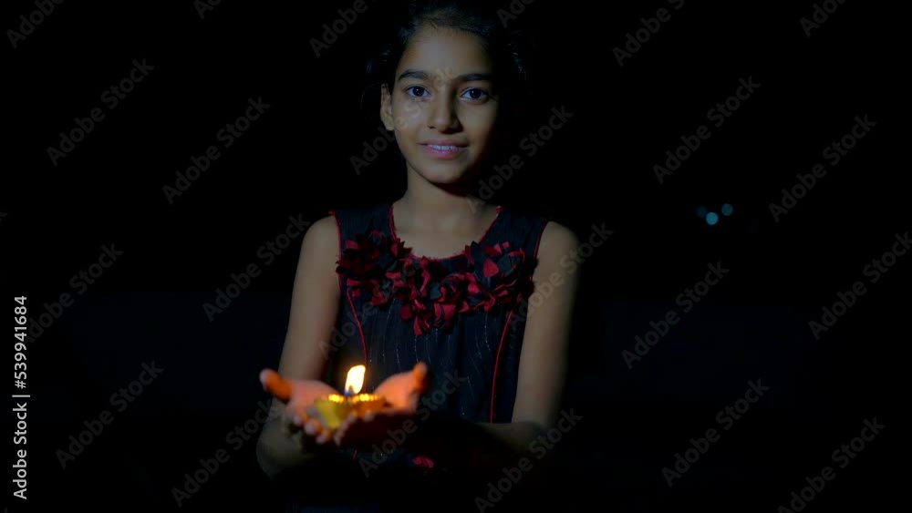 Indian Festival Diwali. Indian girl holding diya for Diwali. girl holding lit diya lamp in hands, closeup. Diwali celebration Indian Festival Diwali. Indian girl holding diya for Diwali. girl holding lit diya lamp in hands, closeup. Diwali celebration