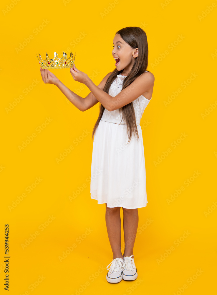 shocked teen girl in crown on yellow background shocked teen girl in crown on yellow background