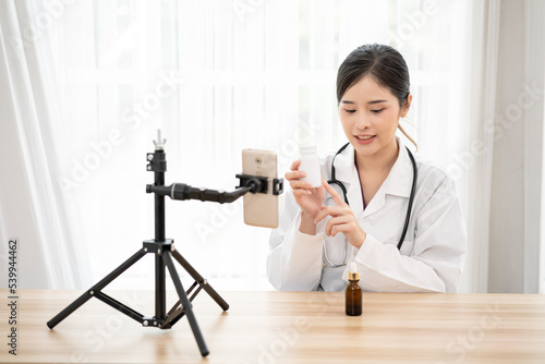 Asian female doctor who is remotely consulting with a patient by using smartphone. Telehealth concept. telemedicine online service. hospital clinic health care service, or internet technology concept
