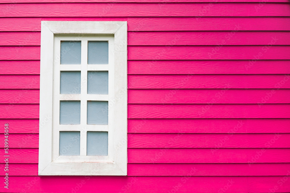 old white window frame on pink decorative wooden wall panel with copy space, selective focus on the window old white window frame on pink decorative wooden wall panel with copy space, selective focus on the window