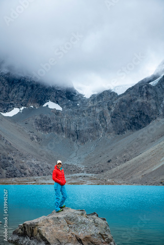 Woman enjoys Blaisvatnet, Blue lake is a polular hiking destination, with mountains of the Lyngen Alps, Lyngenfjord, Troms og Finnmark, Norway