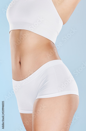 Health, body care and slim woman on diet, model for slimming and dieting in blue background studio. Beauty, wellness and female figure in white underwear for healthy lifestyle, exercise and fitness