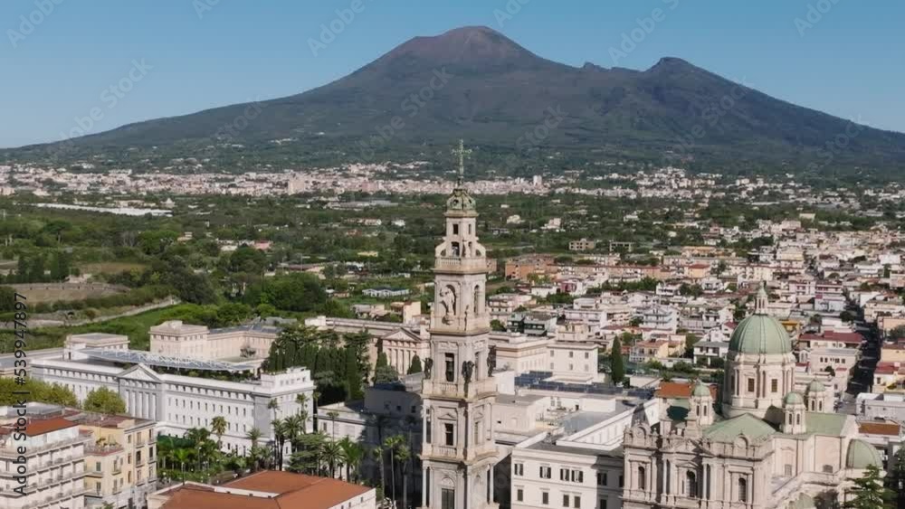 Ancient Architecture Of Bell Tower Of The Shrine of the Virgin of the Rosary of Pompei In Italy. Mount Vesuvius In Background. aerial Ancient Architecture Of Bell Tower Of The Shrine of the Virgin of the Rosary of Pompei In Italy. Mount Vesuvius In Background. aerial