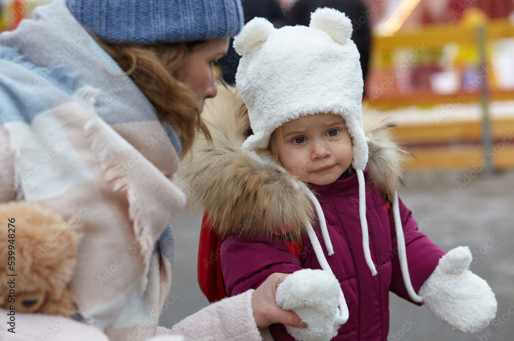Mother and daughter are walking around the city on Christmas and New Year holidays. Parent and little child having fun outdoors Mother and daughter are walking around the city on Christmas and New Year holidays. Parent and little child having fun outdoors