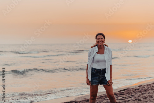 Happy Carefree Woman Enjoying Beautiful Sunset on the Beach. Selective focus 