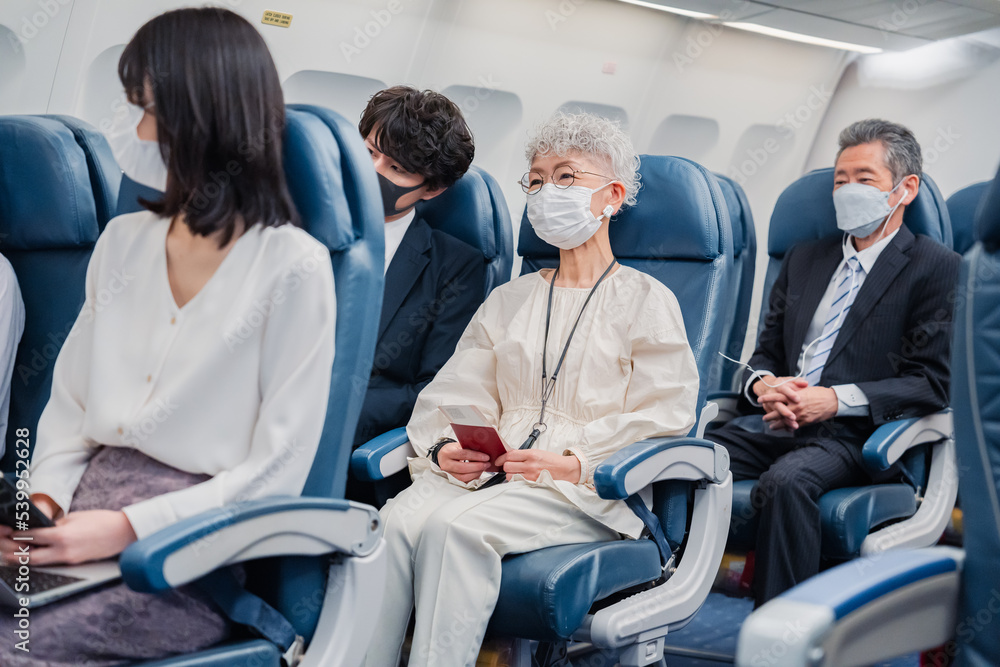 マスクをして飛行機に乗る乗客 マスクをして飛行機に乗る乗客