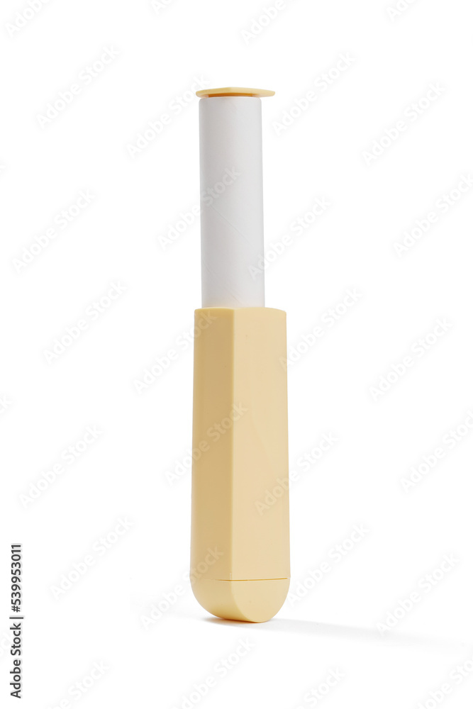Close-up shot of a portable lint roller remover for clothes with a handle. The plastic lint brush roller for cleaning small particles is isolated on a white background. Side view. Close-up shot of a portable lint roller remover for clothes with a handle. The plastic lint brush roller for cleaning small particles is isolated on a white background. Side view.