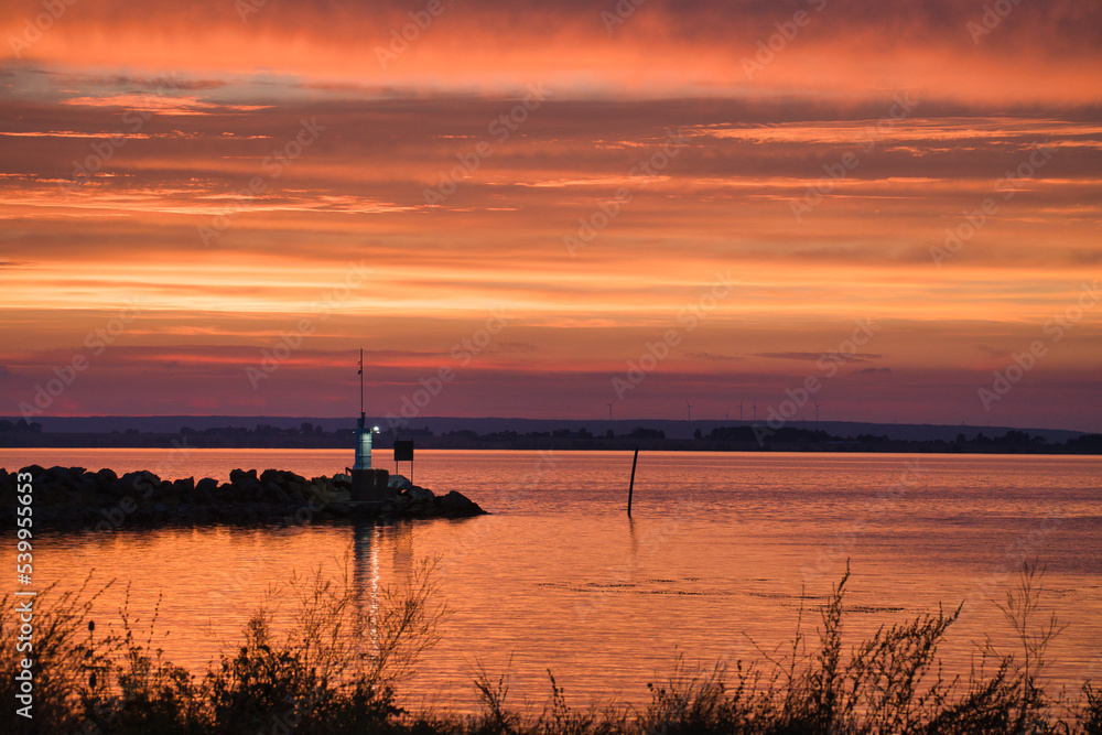 Sunset in Sweden at the harbor of lake Vaettern. Lighthouse in the background