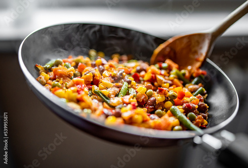 cooking tasty vegetable mix with corn, pea, beans in pan on kitchen