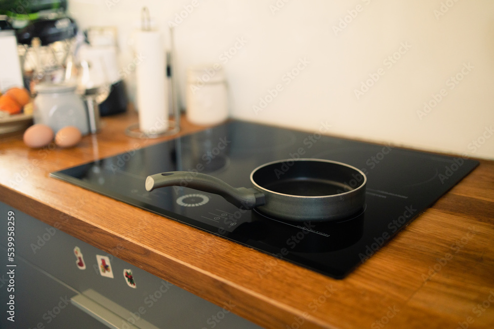 Frying pan in modern kitchen with induction stove. High quality photo Frying pan in modern kitchen with induction stove. High quality photo