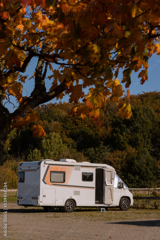 Camper van with open door on a campsite in autumn. Camper van with open door on a campsite in autumn.