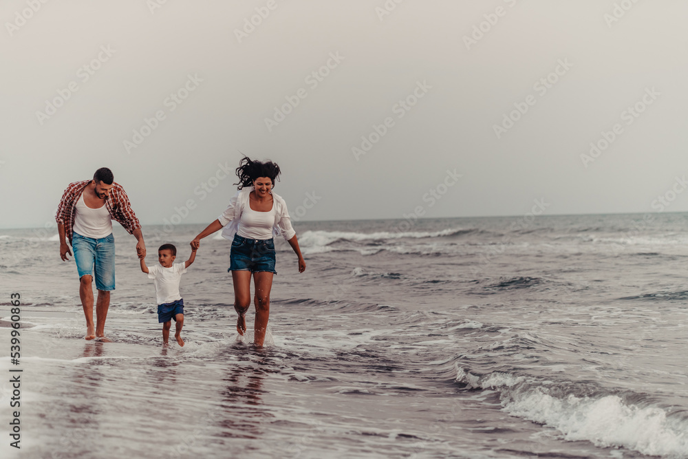 The family enjoys their vacation as they walk the sandy beach with their son. Selective focus 