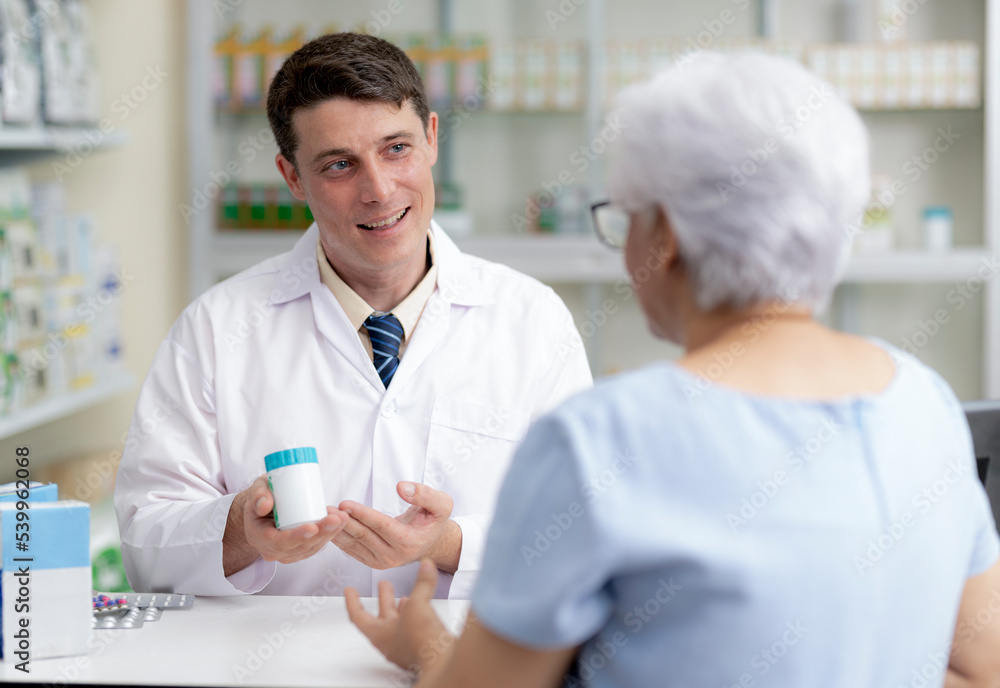 Young man caucasian pharmacist gives advice to patients.