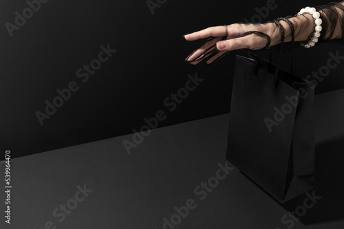 Woman hand with shopping bag for Black Friday sale in studio closeup. Happy time for shopaholics. Profitable purchases making (ID: 539964470)