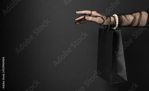 Woman hand with shopping bag for Black Friday sale in studio closeup. Happy time for shopaholics. Profitable purchases making (ID: 539964484)