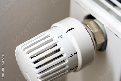 Steigende Heizkosten und Ölpreise in der Krise: Temperatur zuhause mit dem Heizungsthermostat runter regeln und Energie sparen - Closeup Thermostat