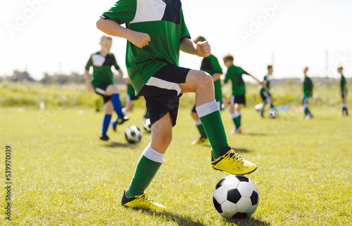 Outdoor Physical Education for Children. Football Education for Kids. Young Coach With Kids in Soccer Team on Training Unit. Youth Team Coach Training School Boys in Football Soccer © matimix