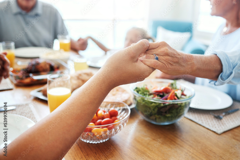 Christian, family and pray for food holding hands for lunch together at home dining table. Faith, gratitude and prayer of thanks to God for meal with young and senior relatives in house.