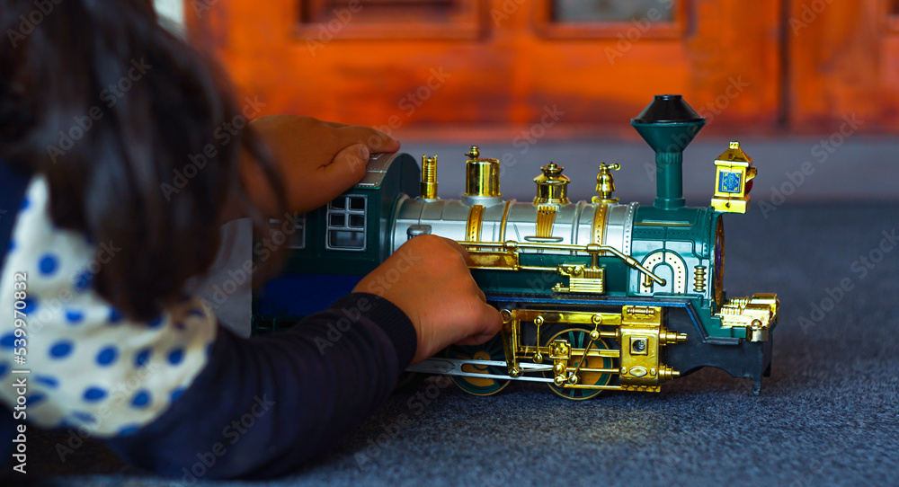 The girl is playing with a plastic train The girl is playing with a plastic train