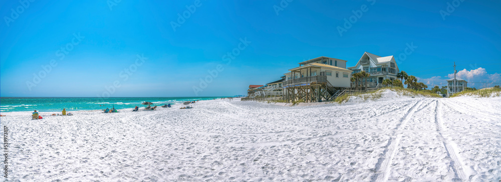 Beach houses with people at the front near the water on a beach at Destin, Florida Beach houses with people at the front near the water on a beach at Destin, Florida