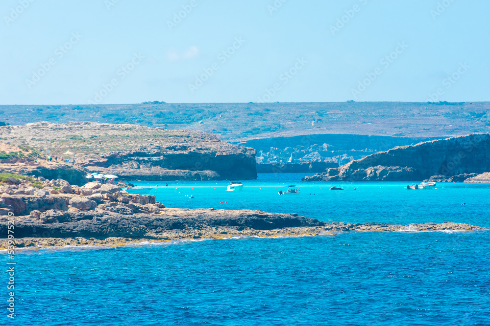 Comino, Malta, 22 May 2022: Tourists swimming in the crystal clear water of the Blue Lagoon Comino, Malta, 22 May 2022: Tourists swimming in the crystal clear water of the Blue Lagoon