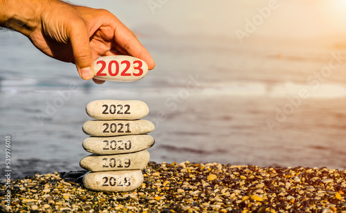 Happy new year 2023 replace old 2022. New Year 2023 is coming concept idea on beach. Creative photo image can be used as display, printed canvas, website banner, social media post.