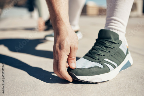 Shoes  hand and stretching with a sports man touching his toes during an exercise or fitness warmup in the city. Health  training and workout with a male athlete getting ready for competition closeup