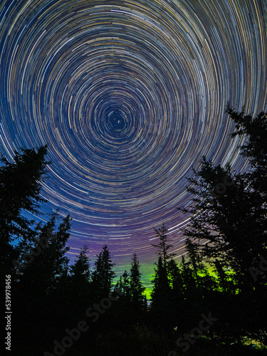 Long exposure astrophotography showing the stars and the northern lights in Denali National Park