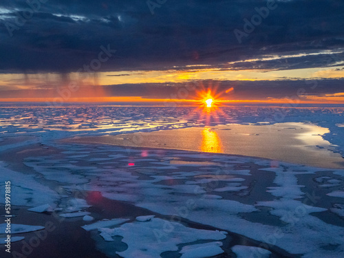 Sunset and rain showers in the heavy pack ice in McClintock Channel, Northwest Passage, Nunavut, Canada photo