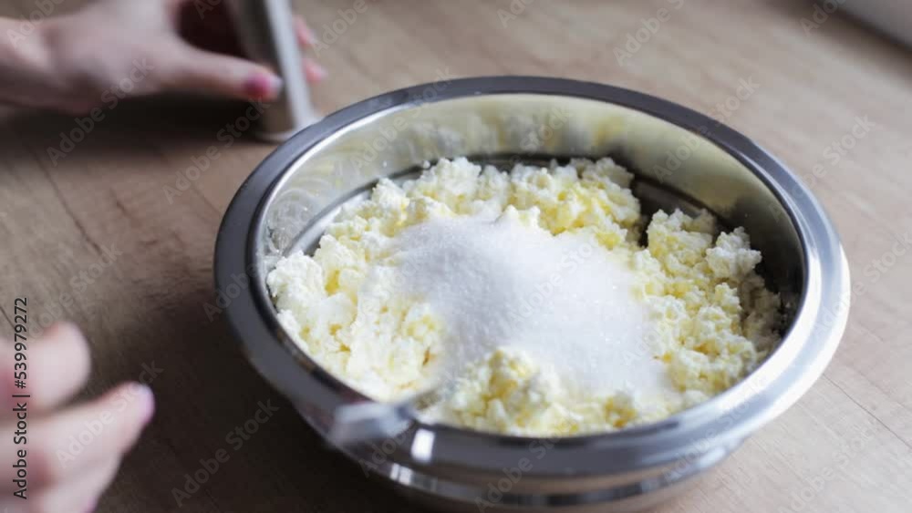 A woman prepares a curd dessert in the kitchen at home. Preparing dough for baking. Home kitchen. A woman prepares a curd dessert in the kitchen at home. Preparing dough for baking. Home kitchen.