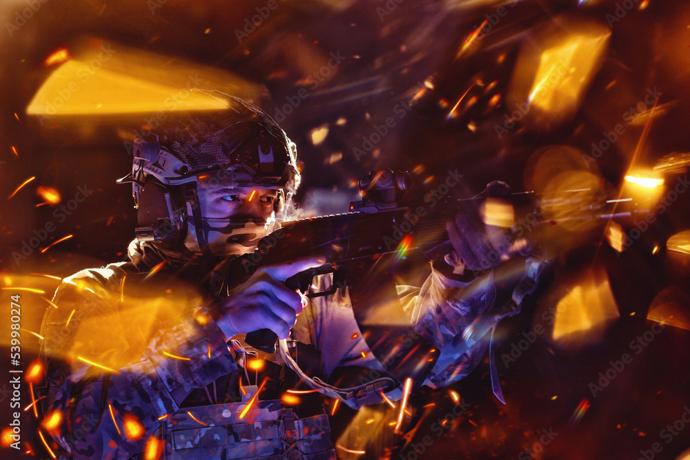 Army soldier in Combat Uniforms with an assault rifle and combat helmet night mission dark background. Blue and purple gel light effect. Army soldier in Combat Uniforms with an assault rifle and combat helmet night mission dark background. Blue and purple gel light effect.