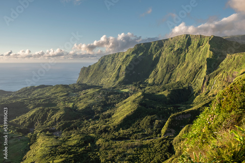 View at sunset of the mountains on the west side of Flores with lush green vegetation and some clouds, Flores Island, The Azores, Atlantic photo
