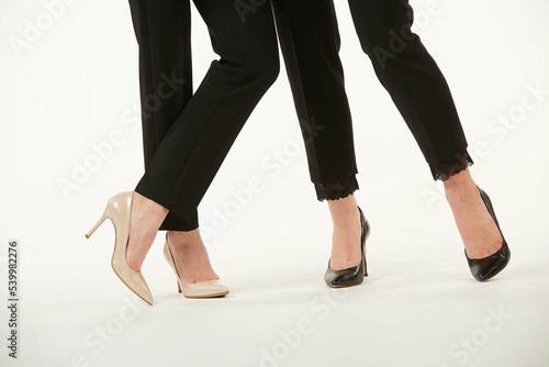 Women's feet in shoes. Pure white background.