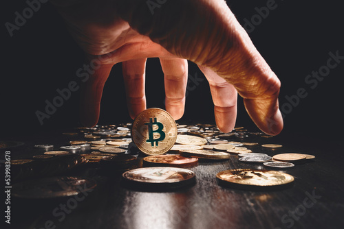 Bitcoin. Cryptocurrency Gold Bitcoin, BTC, Bit Coin. Macro shot of bitcoin coins isolated on black background with human hand. Blockchain technology, bitcoin mining concept.