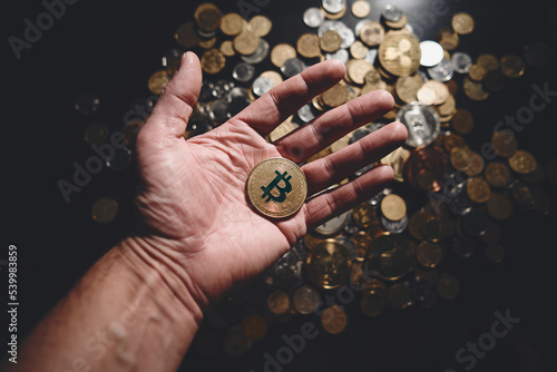 Bitcoin. Cryptocurrency Gold Bitcoin, BTC, Bit Coin. Macro shot of bitcoin coins isolated on black background with human hand. Blockchain technology, bitcoin mining concept.