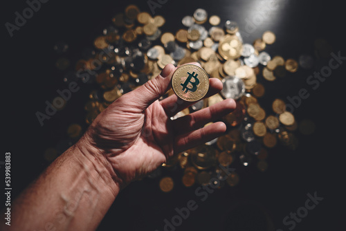 Bitcoin. Cryptocurrency Gold Bitcoin, BTC, Bit Coin. Macro shot of bitcoin coins isolated on black background with human hand. Blockchain technology, bitcoin mining concept.