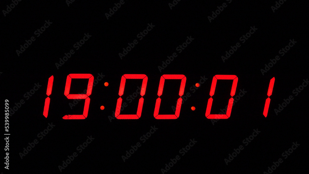 Digital timer on a black background. Light panel with red numbers