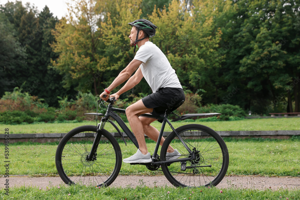 Man riding bicycle on road at park