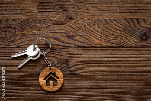 Wooden house shaped keychain with keys. Real estate concept © 9dreamstudio