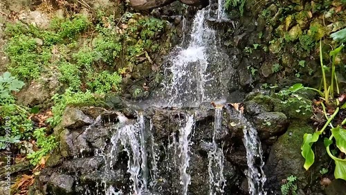Slow motion of pure natural waterfall. Water falls down from the rock in the forest, slow motion.