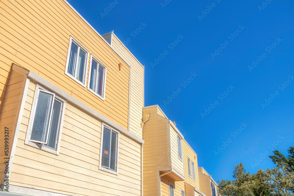 Low angle view of an apartment building with casement windows and wood lap siding in San Francisco