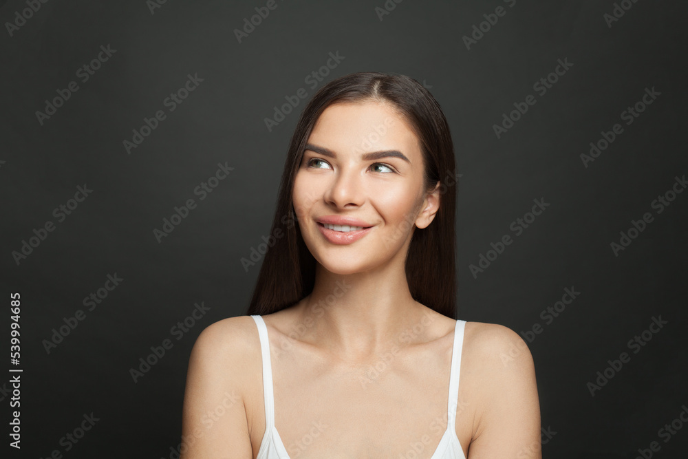 Cute female face. Pretty woman looking up and smiling on black background