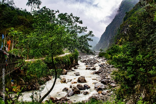 High-angle of a muddy, flowing mountain river in Chopta valley Lachen, Sikkim, India photo