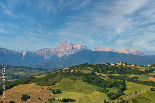 Panoramaansicht auf eine hügelige Landschaft und dem Gebirge Gran Sasso bei leicht bewölkten Himmel in  der Region Abruzzien, Italien photo