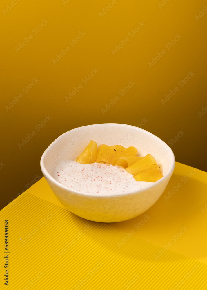 porridge with pineapple on a yellow background porridge with pineapple on a yellow background