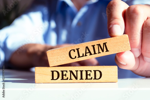 Wooden blocks with words 'Claim denied'.