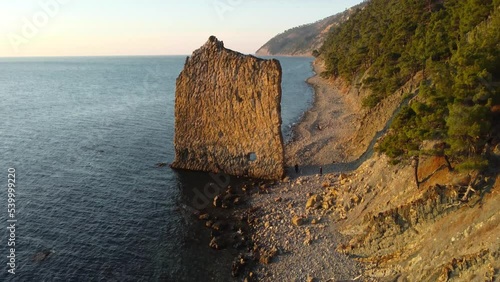 Lonely rock in the form of a wall on the seashore, drone flight