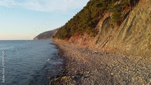 Coastline of rocky shore and blue sea, drone flight