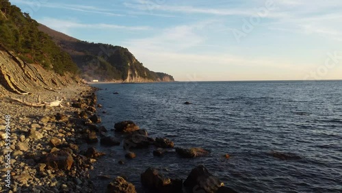 Coastline of rocky shore and blue sea, drone flight
